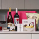 Romantic Night In Hamper. A countertop displays a selection of gift items. There are two bottles of wine, one with a label that reads "LOVE." A glass of red wine is filled beside the bottles. Additionally, there are gourmet snacks, including potato chips in a bag labeled "Keogh's," a box of chocolates from "Lily O'Briens," and a small jar with a decorative label. The background features a pink gift box and a minimalist kitchen setting.Romantic Night In Hamper. A countertop displays a selection of gift items. There are two bottles of wine, one with a label that reads "LOVE." A glass of red wine is filled beside the bottles. Additionally, there are gourmet snacks, including potato chips in a bag labeled "Keogh's," a box of chocolates from "Lily O'Briens," and a small jar with a decorative label. The background features a pink gift box and a minimalist kitchen setting. Romantic Night In Hamper. A countertop displays a selection of gift items. There are two bottles of wine, one with a label that reads "LOVE." A glass of red wine is filled beside the bottles. Additionally, there are gourmet snacks, including potato chips in a bag labeled "Keogh's," a box of chocolates from "Lily O'Briens," and a small jar with a decorative label. The background features a pink gift box and a minimalist kitchen setting.Romantic Night In Hamper. A countertop displays a selection of gift items. There are two bottles of wine, one with a label that reads "LOVE." A glass of red wine is filled beside the bottles. Additionally, there are gourmet snacks, including potato chips in a bag labeled "Keogh's," a box of chocolates from "Lily O'Briens," and a small jar with a decorative label. The background features a pink gift box and a minimalist kitchen setting.